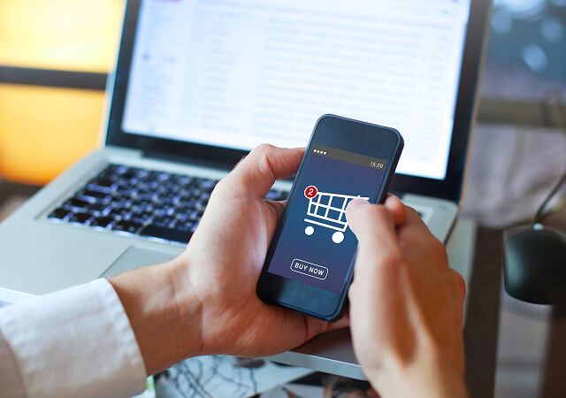 Manos de una persona utilizando un móvil navegando por una ecommerce